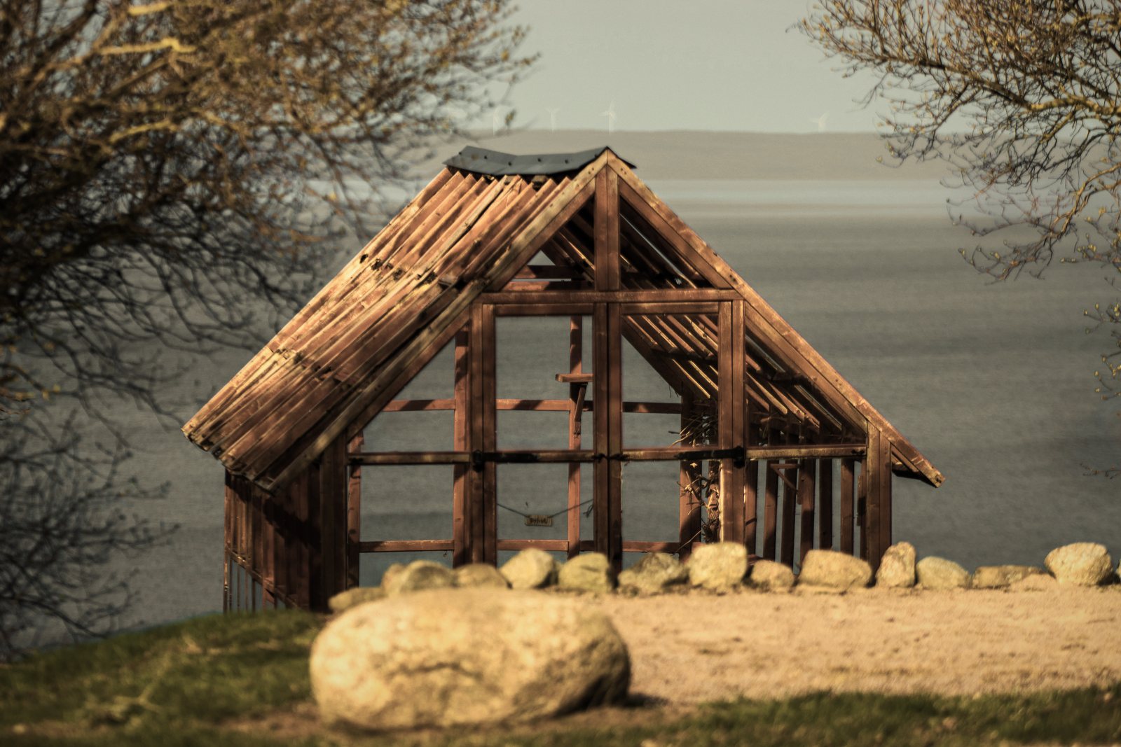 Ossature bois d'un petit bâtiment à deux pans en cours de montage, posée au bord de l'eau, photo d'illustration