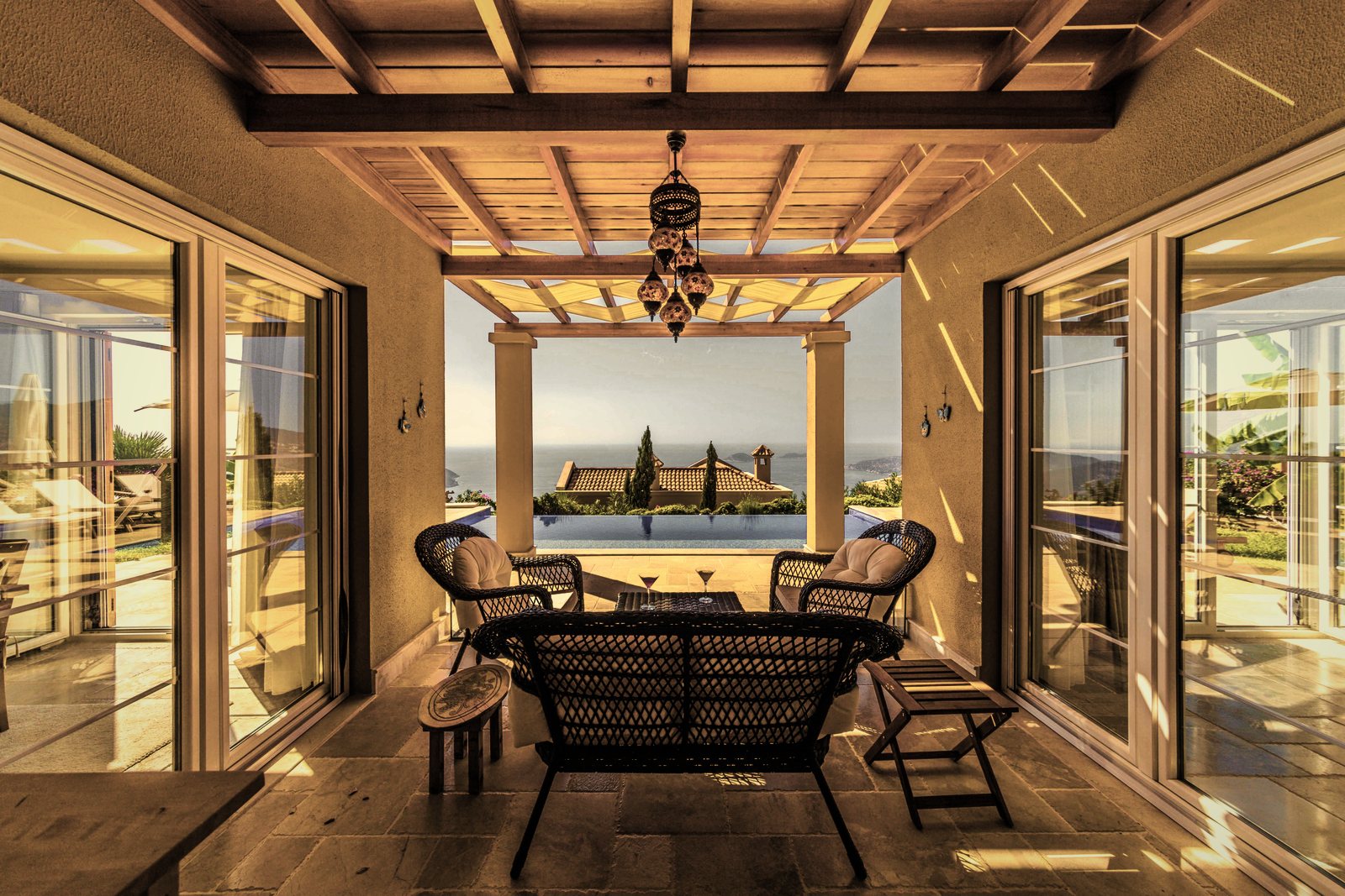 Loggia couverte d'un plafond à caissons en bois, entre deux grandes baies, ouverte sur un paysage, photo d'illustration