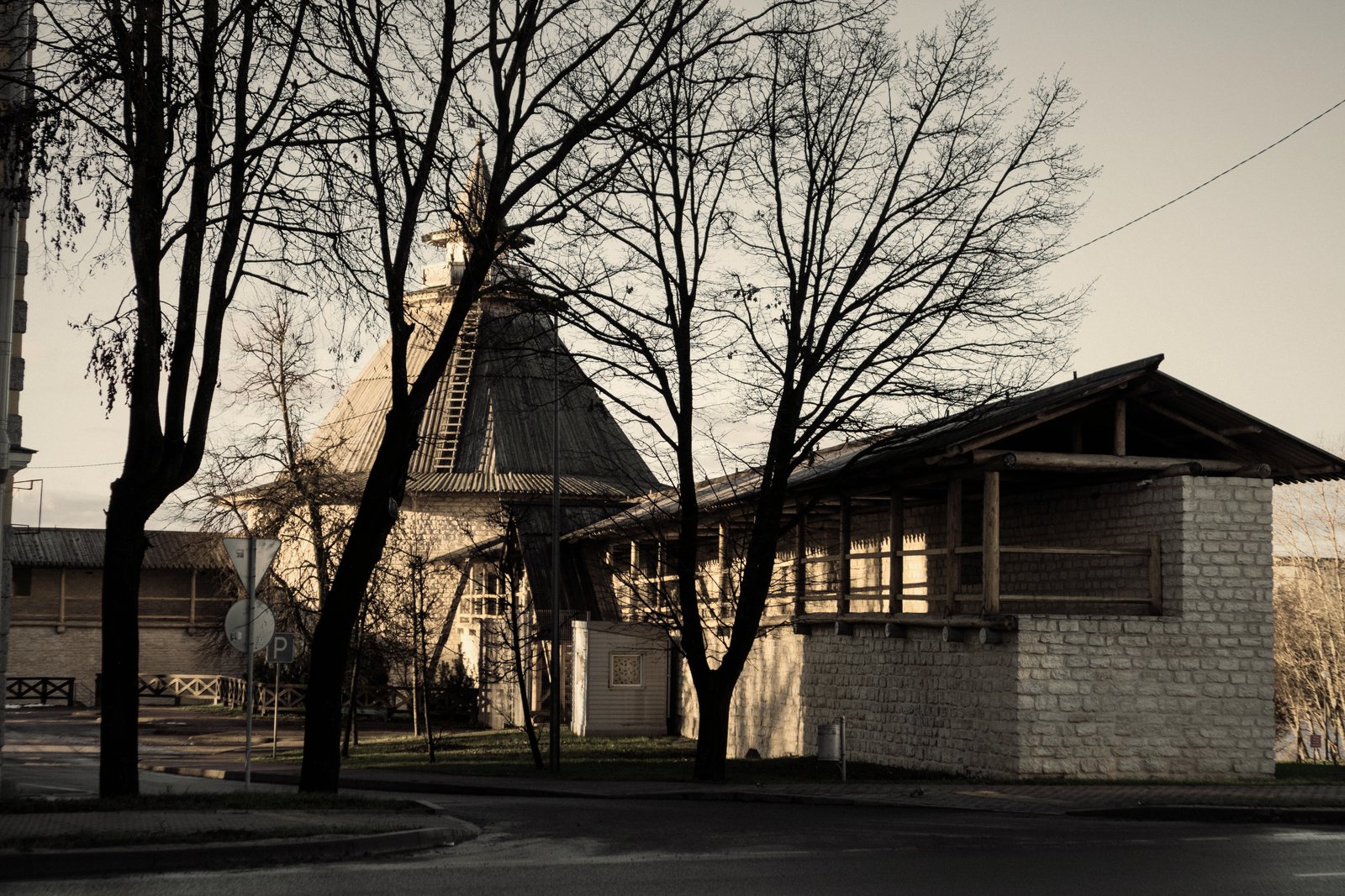 Bâtiment associant un volume en pierre de taille et une structure bois sous une large toiture, photo d'illustration