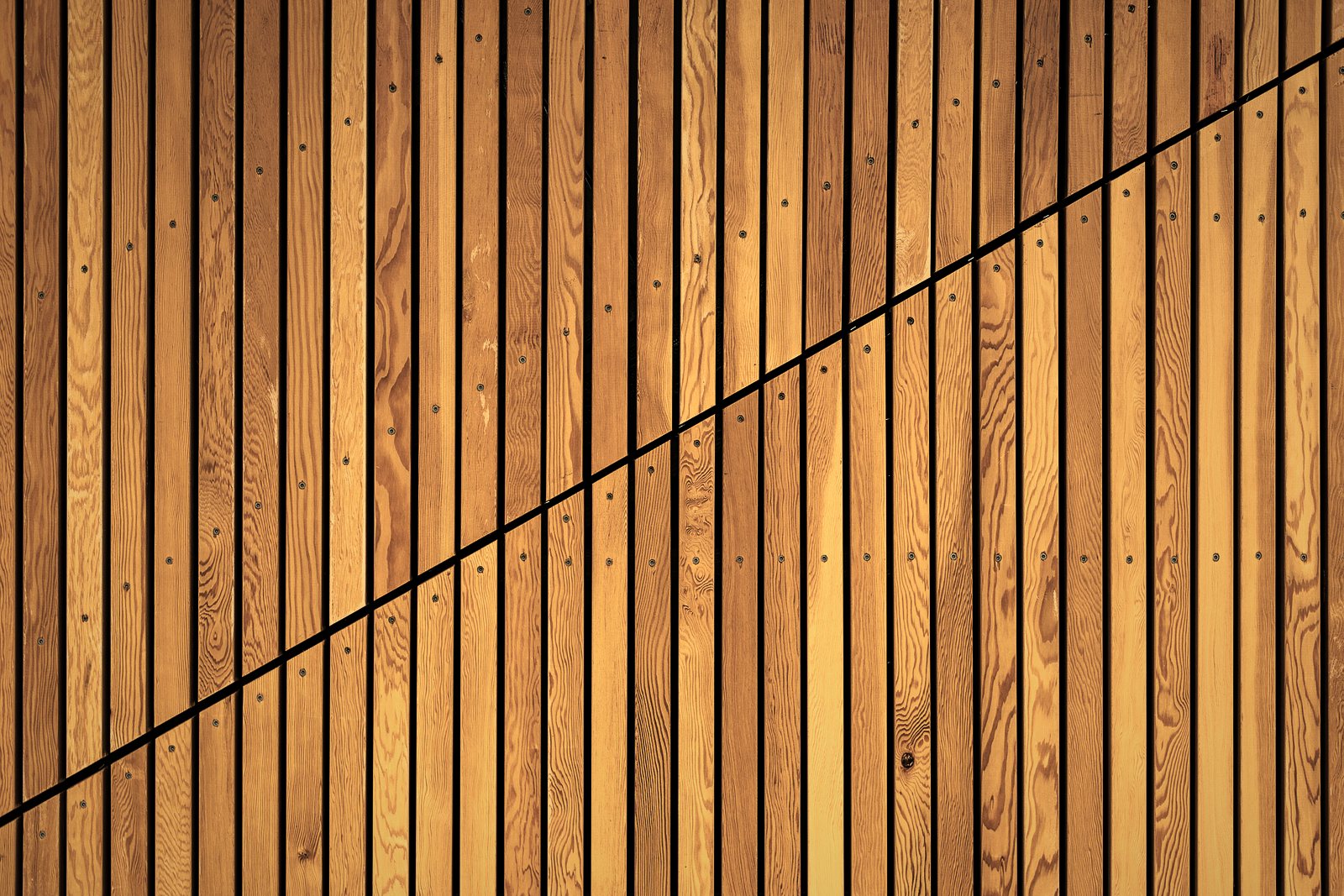 Lames de bois verticales à claire-voie posées sur une façade, vues de près, photo d'illustration