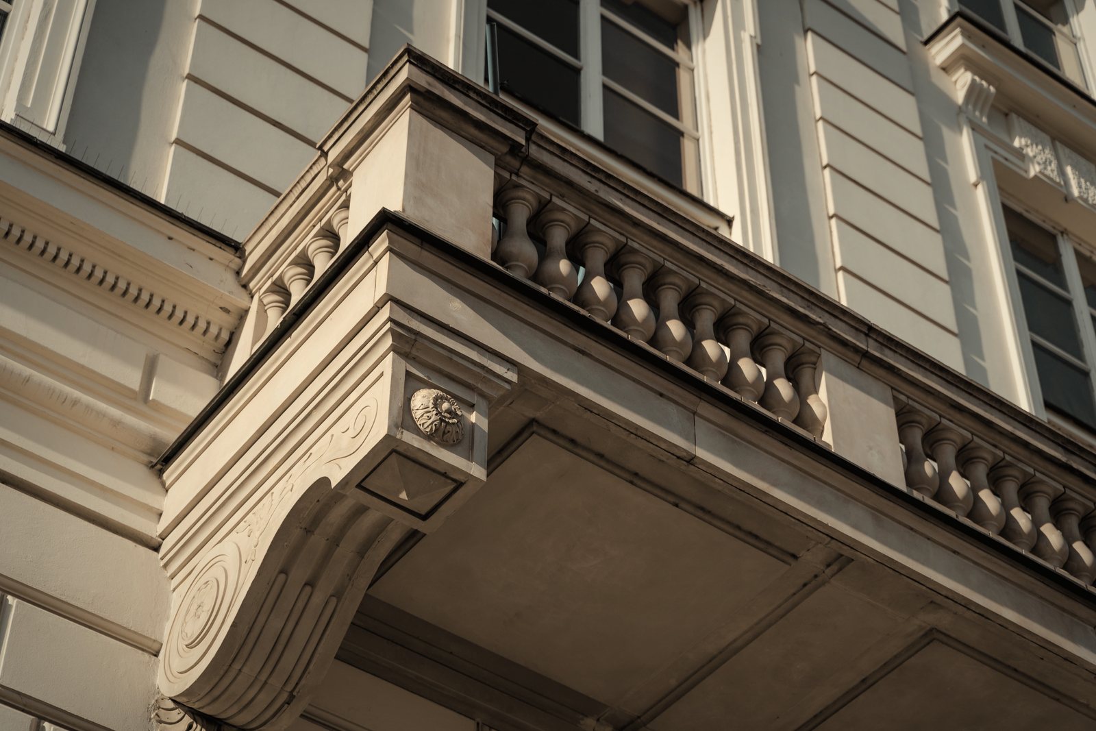Dessous d'un balcon ancien en pierre moulurée à balustres, vu en contre-plongée, photo d'illustration