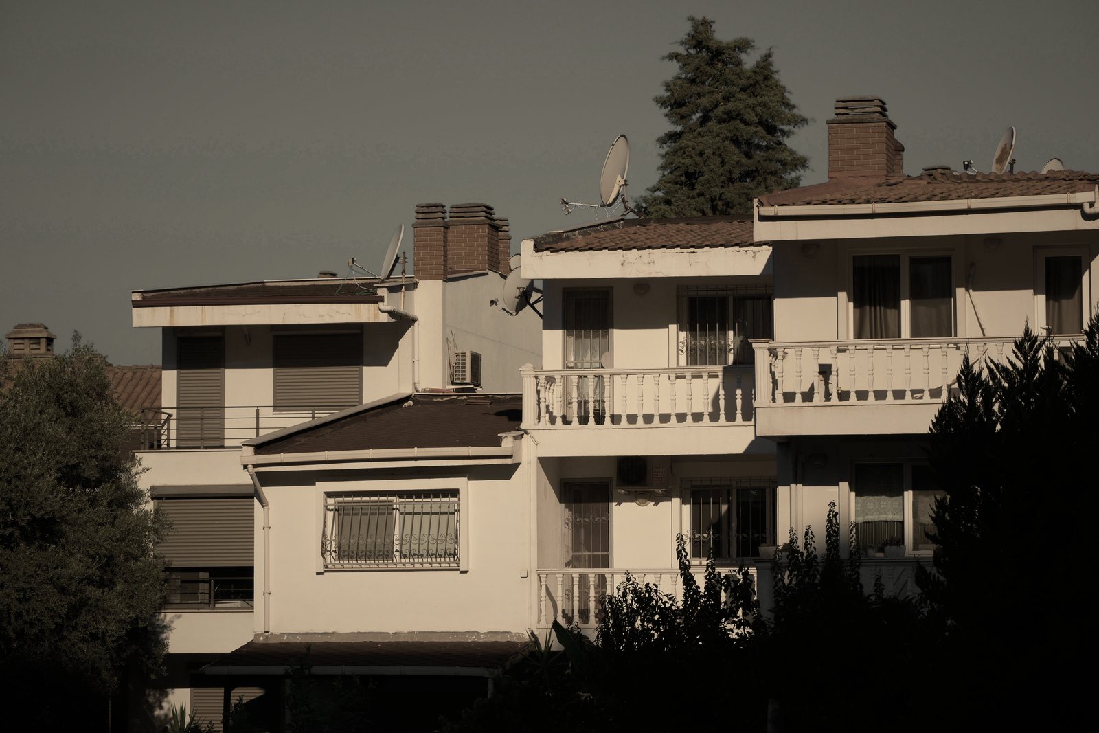 Petites résidences de deux étages à terrasses et toits de tuiles, dans l'ombre du soir, photo d'illustration