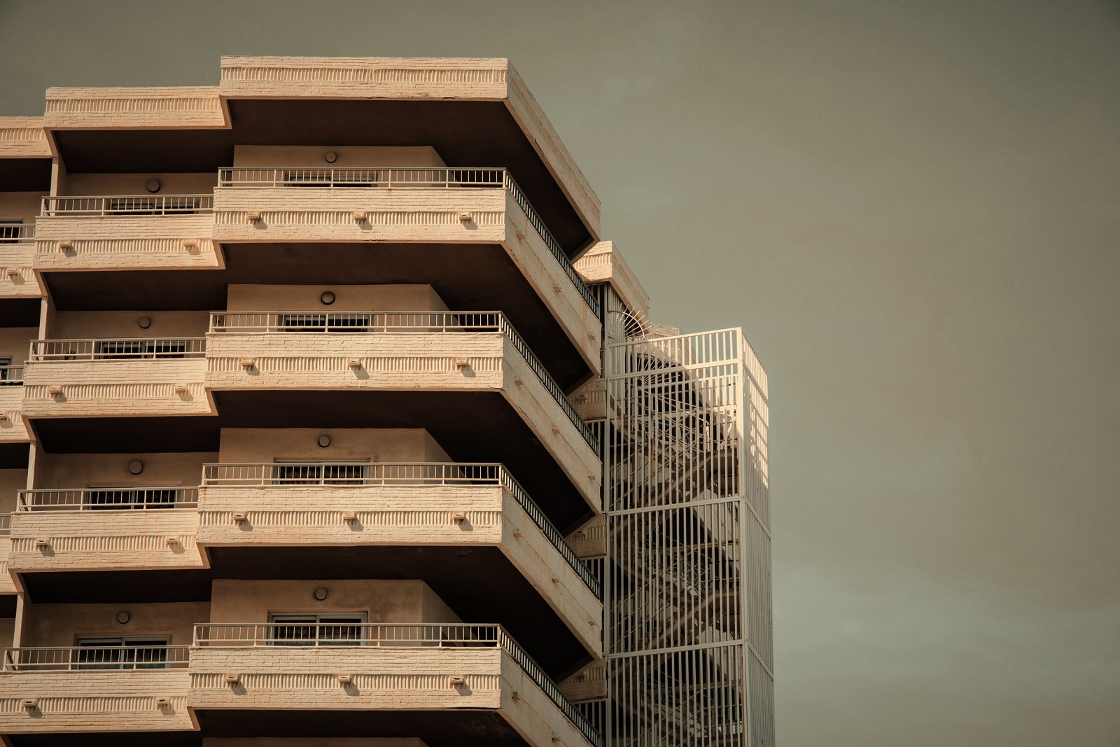 Immeuble à balcons en gradins décalés et escalier métallique extérieur, en contre-plongée, photo d'illustration