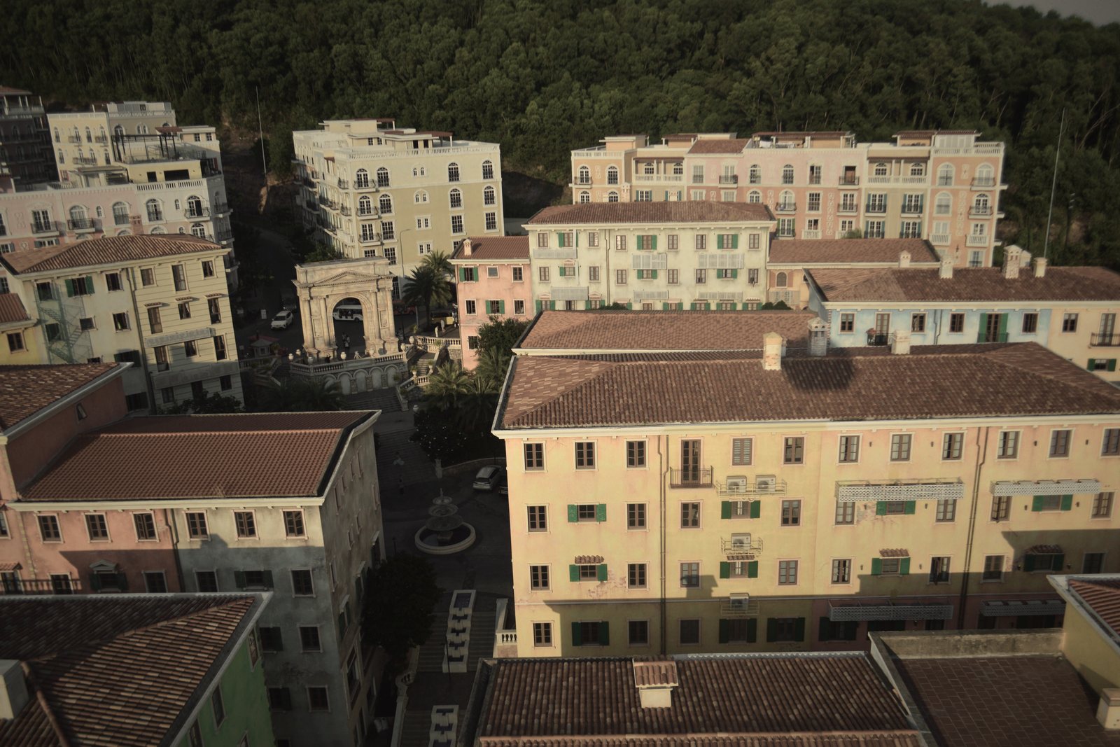 Petits immeubles aux façades pastel et toits de tuiles vus d'en haut, forêt en arrière-plan, photo d'illustration